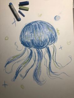 a drawing of a jellyfish with crayons on the table next to it