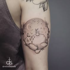 a woman with a tattoo on her arm has a cat sleeping under the moon and flowers