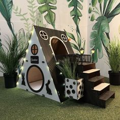 a dog house made out of cardboard and decorated with plants