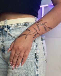 a woman's hand with a small tattoo on her left arm and the bottom half of her body