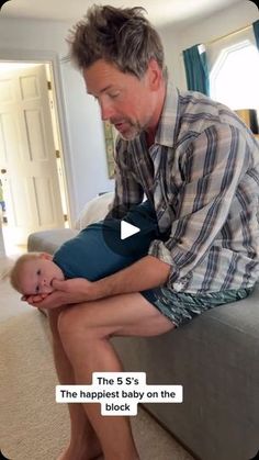 a man sitting on top of a couch holding a baby