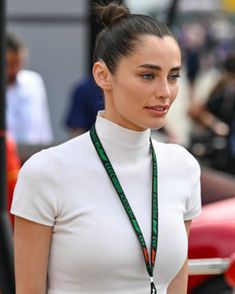 a woman wearing a white top and green lanyard