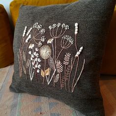 an embroidered pillow with flowers on it