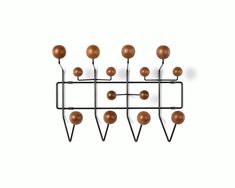 a metal rack with brown balls hanging from it's sides on a white wall