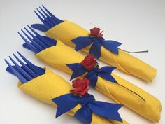 three yellow and blue hair combs with red flowers on them, sitting next to each other