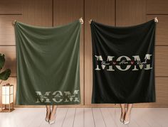 two towels with the words mom and love printed on them are hanging in front of a wooden wall