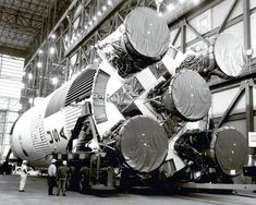 an old black and white photo of a space shuttle being unloaded in a hangar