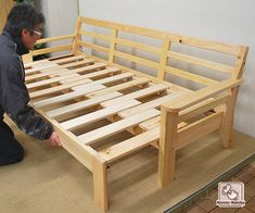 a man working on a wooden bed frame