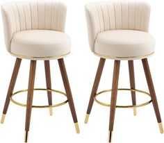 two white bar stools with wooden legs and gold trim on each side, one has a beige upholstered seat