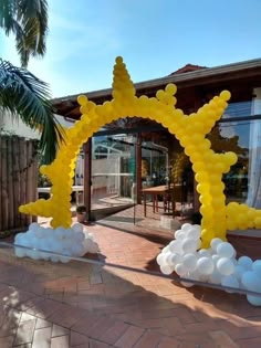 a large arch made out of balloons in front of a house