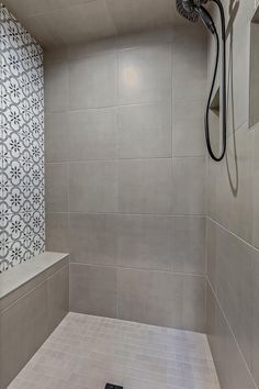 a bathroom with tiled walls and floor, shower head in the corner next to the bathtub