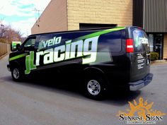 a van parked in front of a building with the word racing on it's side