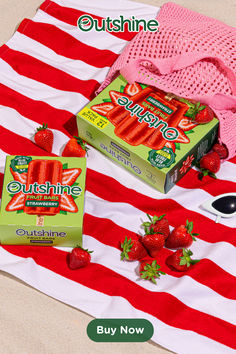 two boxes of strawberries on a red and white striped towel next to other items