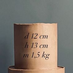 a three tiered cake with writing on the top and bottom, in front of a blue wall