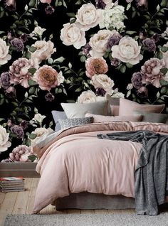 a bed room with a neatly made bed and flowers on the wall behind it in front of a black background