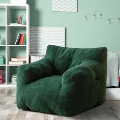 a green bean bag chair sitting in front of a bookshelf