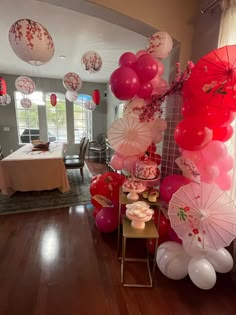 balloons and umbrellas are on display in the dining room at a valentine's day party