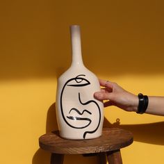 À travers le visage stylisé et la déformation de la céramique vers l'intérieur le Vase Visage symbolise une approche artistique qui embrasse à la fois l'abstraction et l'expressionnisme. Vu de profil, le vase est déformé vers l'intérieur, une invitation à l'introspection ? Détails et ambiance : Disponible en 3 tailles de 30cm de hauteur, 24cm et 20cm respectivement, cette pièce exclusive et originale ravira ceux qui aiment les œuvres qui poussent à la réflexion ou qui racontent une histoire. Ell Vase