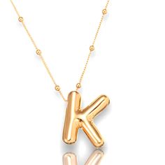 a gold necklace with the letter k on it