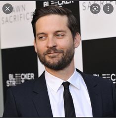 a man in a suit and tie smiling at the camera