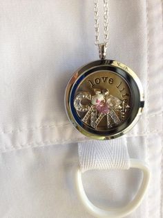 a pocket watch with the word love written on it is attached to a white necklace