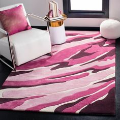 a pink rug with black and white designs on it in front of a large window