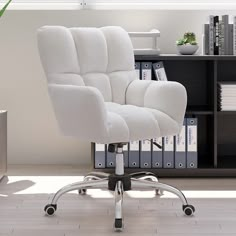 a white office chair sitting on top of a hard wood floor next to a book shelf