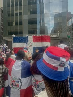 many people are standing in the street with flags on their backs and hats on their heads