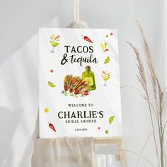 a welcome sign hangs on the wall next to a potted plant and glass vase