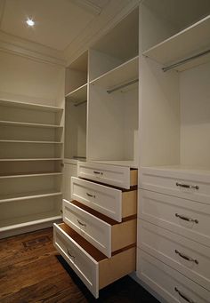 an empty walk in closet with white drawers