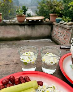 there are two plates with food on the table next to each other and water in glasses