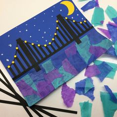 paper collages and crafting materials on a white surface with the night sky in the background