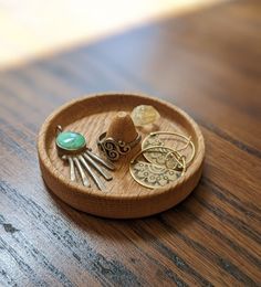 a wooden tray filled with assorted jewelry on top of a table