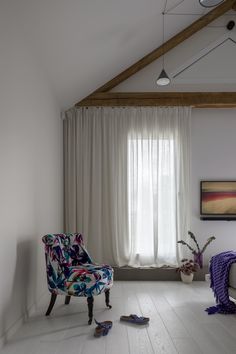 a living room filled with furniture and a window covered in white drapes next to a painting