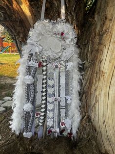 a white and grey feathered dress hanging from a tree