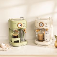 two coffee machines sitting on top of a counter