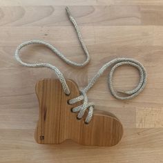 a wooden object with rope on it sitting on top of a wood floor next to a cord