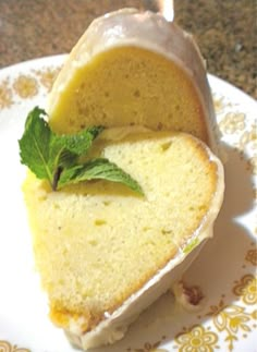 a slice of pound cake on a plate with a mint sprig in it