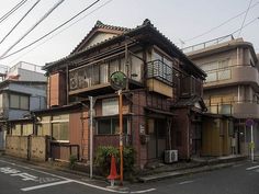 an old wooden building on the corner of a street