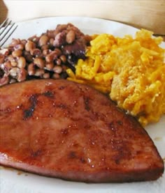 a white plate topped with meat and beans