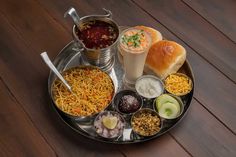 a platter filled with different types of food and condiments on a wooden table