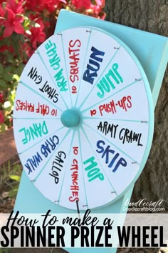 a blue and white sign with words written on it next to a tree in front of red flowers