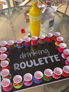 there is a sign that says drinking rouleette with cups around it on the table