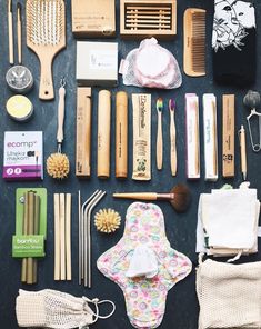 the contents of a travel bag laid out on top of a black table with white and pink accessories