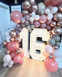 the number sixteen surrounded by balloons and streamers in front of a doorway with an open door