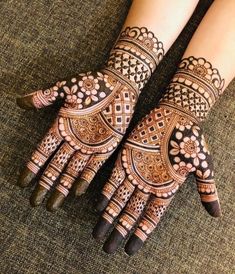 two hands with henna tattoos on them