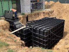 construction workers are working on the side of a building that is being built into dirt