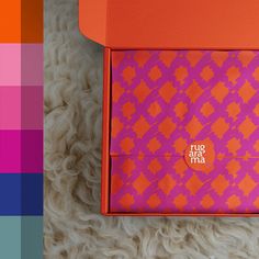 an orange and pink box sitting on top of a white rug