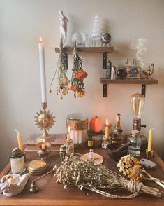 a table topped with lots of different types of candles and other things on top of it