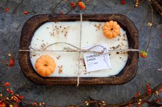 some pumpkins are tied up and placed in a wooden tray on top of the ground